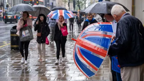 Getty Images Elderly man holding union jack umbrella on Oxford Street looking at other shoppers